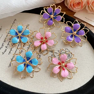 Detailed view of colorful enamel hollow flower pendants with gold-tone metal frames.