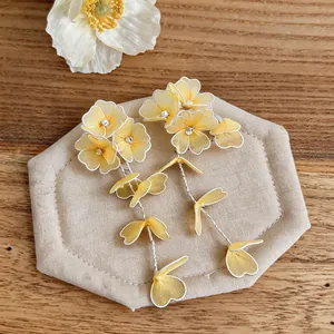 Close-up of elegant handcrafted yellow fabric flower drop earrings with crystal centers