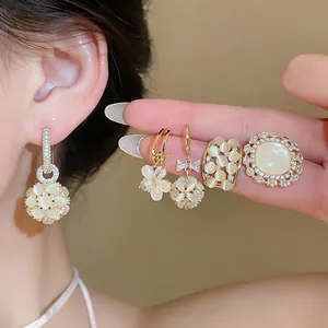 Close-up view of elegant 18k gold plated flower ball earrings and matching zircon ring set