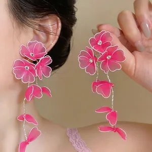 Close-up detail of handmade pink mesh floral drop earrings with sparkling center beads