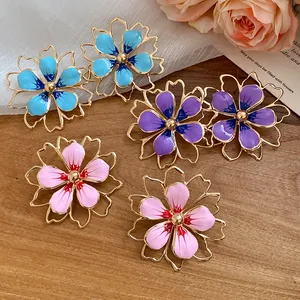 Macro view showing the detailed enamel and hollow metal work of floral jewelry set.