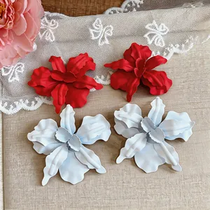 Detailed macro view of matte painted oversized red and white flower stud earrings
