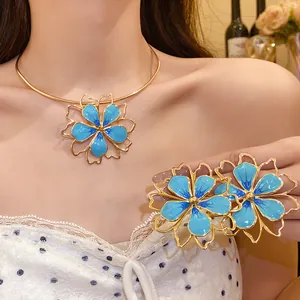 Elegant gold-plated blue enamel flower jewelry set worn by a model in lifestyle shot