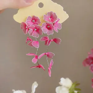 Detailed view of handmade pink floral drop earrings with translucent petals on display