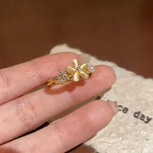Detailed close-up showing the rotating zircon flower and star on this gold open ring