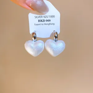 Dettaglio della lucente consistenza della perla a cuore di questi eleganti orecchini in argento