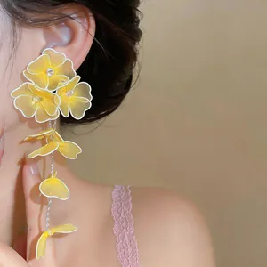 Detailed macro view of yellow handmade woven flower earrings with delicate mesh petals