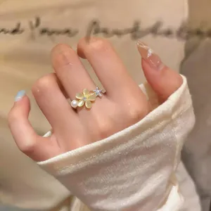 Detailed view of a sweet zircon flower ring featuring cat's eye petals and a pearl