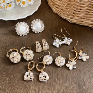 Detailed view of 18k gold plated floral earrings with cat's eye stones and zircons.