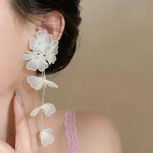 Detailed close-up showing the intricate woven mesh flowers and pearl center on the earring
