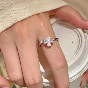 Detail shot of a delicate silver open ring featuring a zircon flower with pink hearts