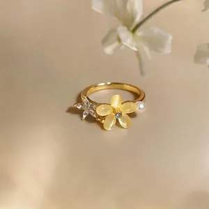 Detailed macro view of an exquisite gold ring featuring a yellow zircon flower and pearl