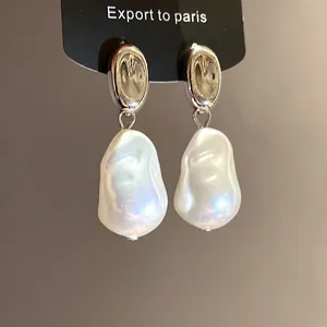 Detailed shot of French retro silver earrings with iridescent baroque pearl pendants