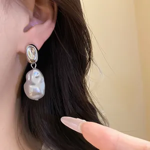 Detail shot of French retro silver earrings with irregular baroque pearl pendants.