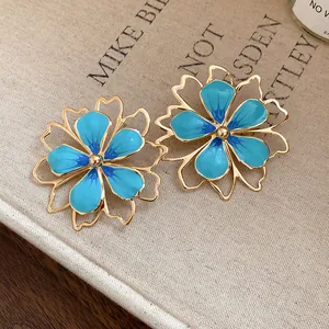 Close-up of elegant blue enamel hollow flower earrings with a gold-plated finish