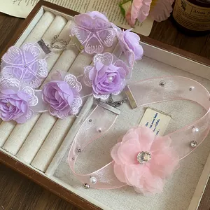 Close-up of elegant purple lace and pink organza flower chokers in a jewelry box