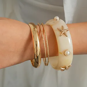 Close-up of the four-piece resort style bracelet set with starfish and pearl accents.