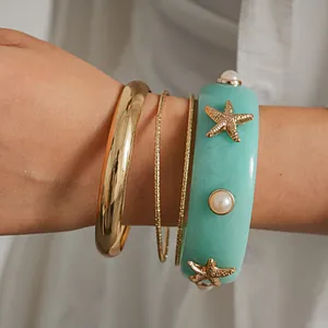 Detailed view of resort-style bracelet set with resin starfish and pearl accents.