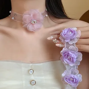 Close-up of pastel organza flower chokers with pearls for summer vacation look.