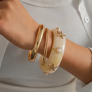 Detailed shot of 4-piece resort-style bracelet set with starfish and pearl accents.
