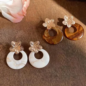 Vintage Maillard style resin flower earrings with gold studs and marble texture.