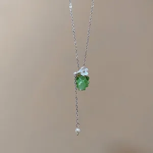 Elegante collana delicata con ciondolo a uva verde traslucida e piccolo fiore bianco.