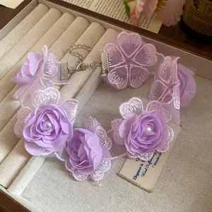 Detail of purple lace choker necklace featuring 3D fabric flowers and faux pearls