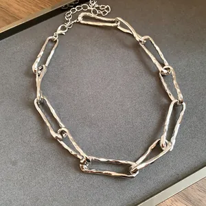 Dettaglio di una collana a catena ritorta argento lucido in uno stile punk unico