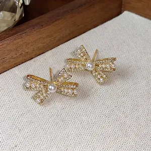 Elegante mit 14K Gold überzogene Schleifen-Ohrstecker mit Zirkonia und Perlen