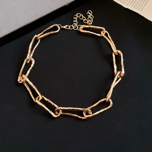 Vista dettagliata di una collana a catena a maglie d'oro ritorte in stile punk audace.
