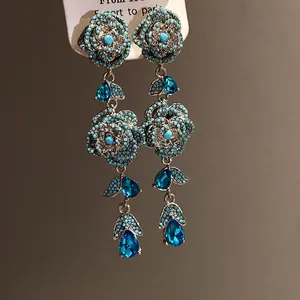 Detailed view of vintage blue flower tassel earrings with sparkling teardrop crystals