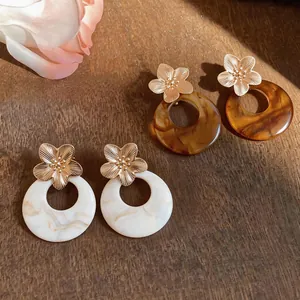 Detailed view of French vintage resin flower earrings in amber and cream white finish