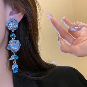 Close-up of vintage-style zircon flower tassel earrings with vibrant blue stones