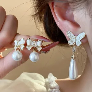 Detailansicht eleganter, 14 Karat vergoldeter Schmetterlings- und Schleifenohrringe mit Perlen