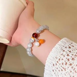 Bracciale vintage con perle di occhio di gatto indossato con elegante polsino