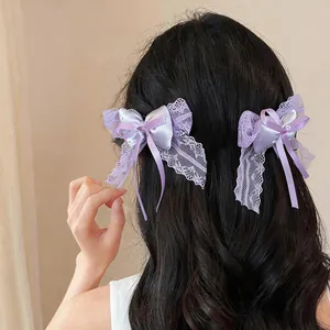 Detailed view of elegant purple lace bow hair clips worn on long wavy hair