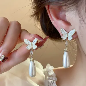 Detailansicht eleganter Schmetterlings-Perlenohrringe mit hochwertiger 14K Goldbeschichtung.