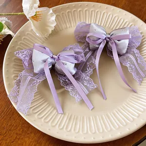 Close-up of elegant purple lace bow hair clips with satin ribbons on a decorative plate