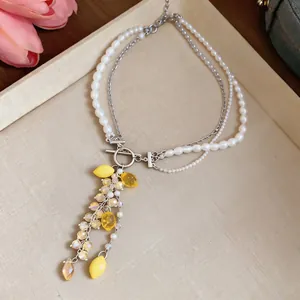 Detail view of layered pearl necklace featuring vibrant yellow lemon resin pendants