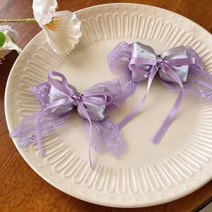 Detailed view of the elegant purple lace bow hair clip with satin center and sparkles