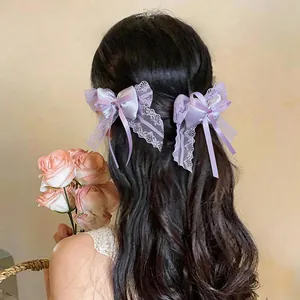 Detailed close-up view of two elegant purple lace bow hair clips worn on styled wavy hair