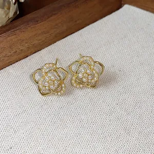 Elegante 14K vergoldete Blumen-Ohrstecker mit feinen Perlen in der Nahaufnahme.