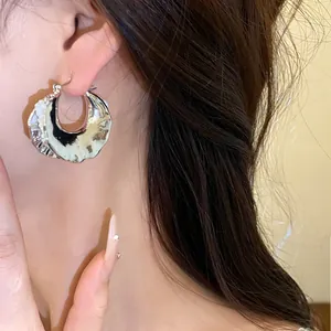 Elegante orecchino a cerchio in argento con perle indossato da una modella di lato