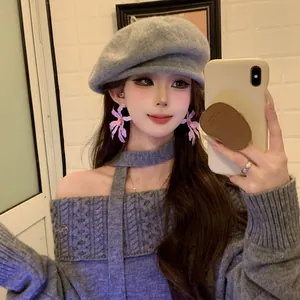 Detailed view of sweet purple flower earrings worn by a model in resort style outfit
