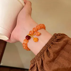 Dettaglio macro di bracciale vintage in pietra occhio di gatto con eleganti ciondoli d'oro