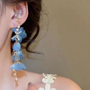Close-up shot of elegant blue fabric flower and pearl tassel ear cuff for non-pierced ears