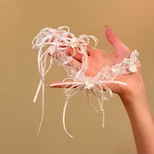 Elegante collana girocollo in pizzo bianco con perle, motivi floreali e delicati fiocchi.