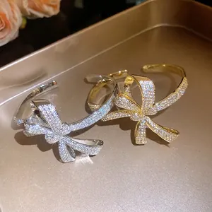 Elegant zirconia-encrusted bow cuff bangles available in gold and silver tones