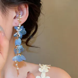 Detailed view of elegant blue fabric flower tassel ear cuff with delicate white pearls