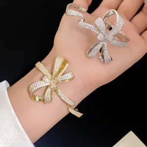 Detailed view of gold and silver bow bracelets encrusted with sparkling cubic zirconia